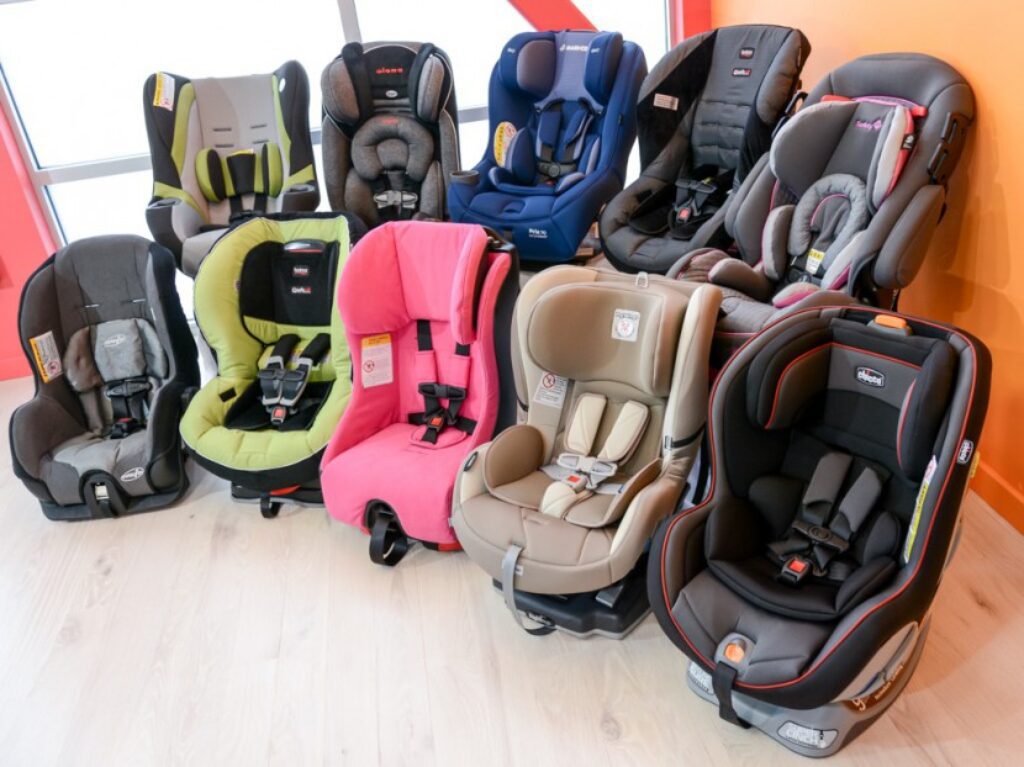 A row of baby car seats in different colors.
	
